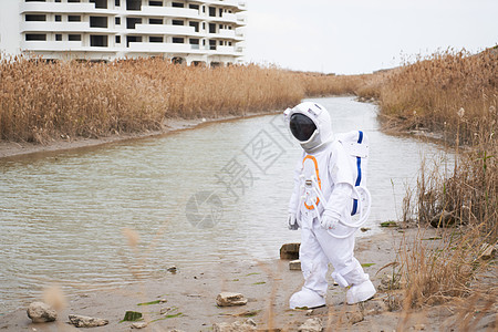 科研楼废弃楼边穿着宇航服的男性探索背景