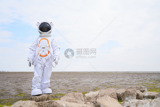 海滩边穿着宇航服的男性图片