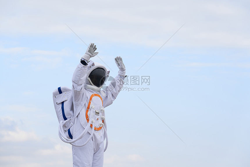 穿着宇航服的男性高举双手图片