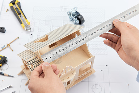 工程师使用尺测量房屋模型高清图片