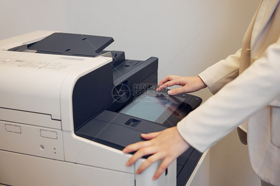 商务白领女性使用打印机手部特写图片