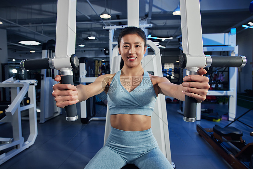 健身房里正在使用蝴蝶机训练的女性图片