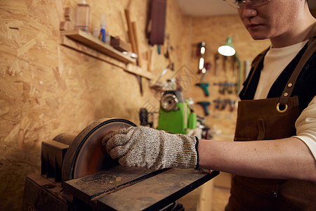 男性工匠打磨工具特写图片