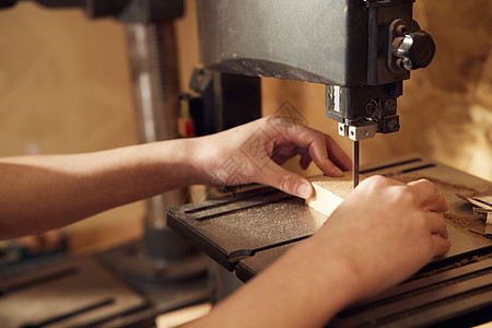 男性工匠切割木块特写图片