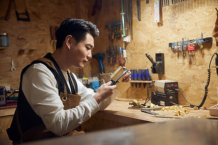 夜晚制作木块的男性工匠图片