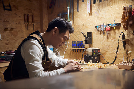 男性工匠夜间制作木块图片