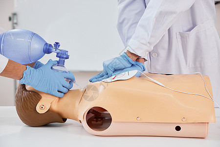 医护人员示范呼吸球囊急救按压方法特写图片