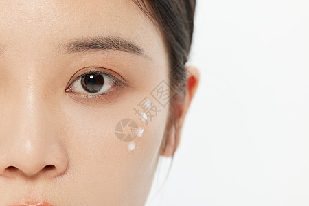 女性面部涂乳液特写图片
