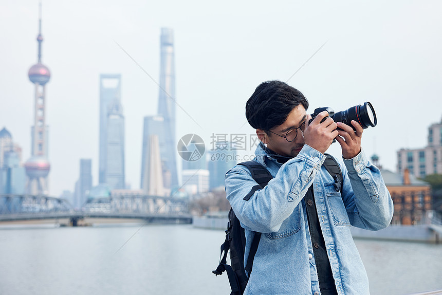 拍摄城市风光照片的青年男性图片