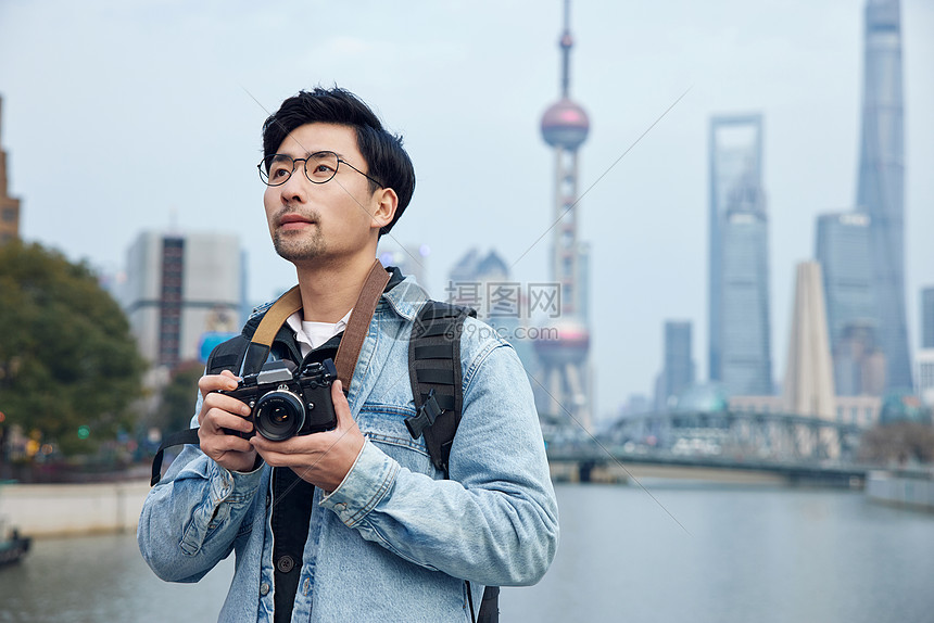 拍摄城市风光照片的青年男性图片