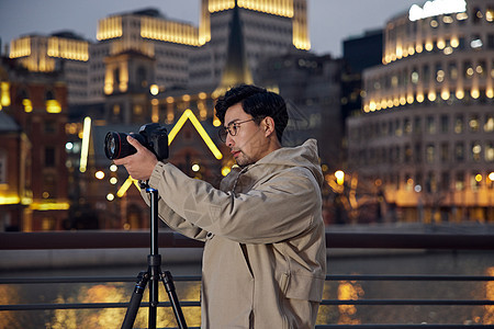 男摄影师拍摄城市夜景图片