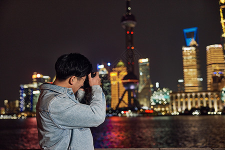 拍摄上海城市夜景的男摄影师图片