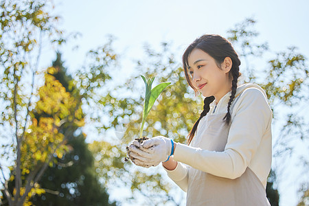 保护环境双手捧着花苗的环保女性背景