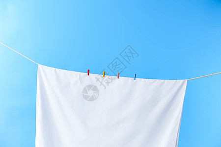 晾衣绳上晾晒着的白毛巾图片