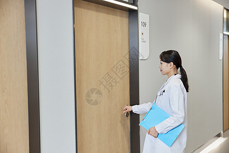 手拿病历本在医院走廊的女医生图片