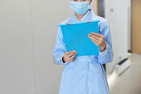 手拿病历夹的护士行走在走廊图片