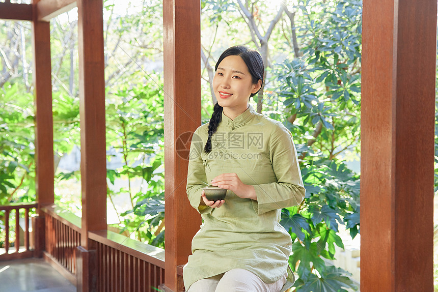 户外赏植品茶看书的青年素雅女性图片