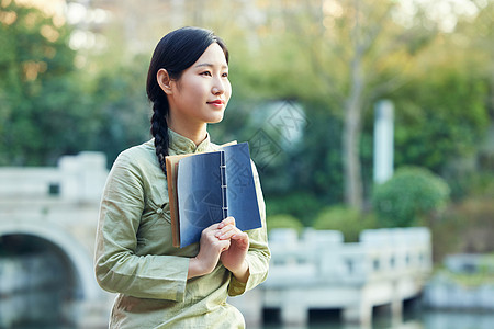 气质女性户外赏植看书图片