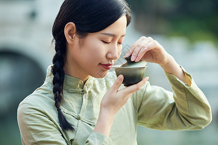 在室外品茶的气质素雅美女背景图片