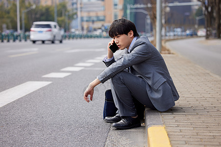 坐在马路边打电话的职场男性图片