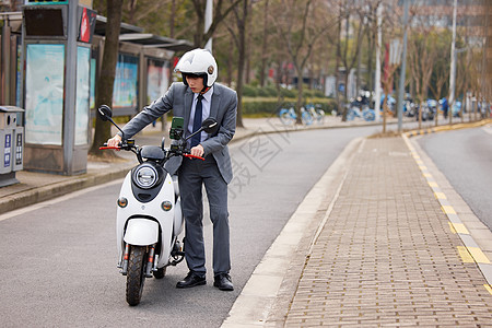 推着电瓶车着急的职场男青年图片