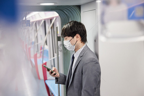 戴口罩乘坐地铁的男性图片