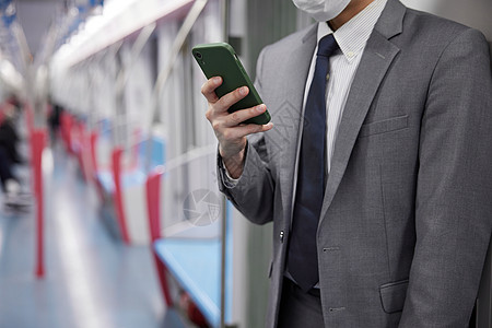 努力工作地铁上玩手机的男性特写背景