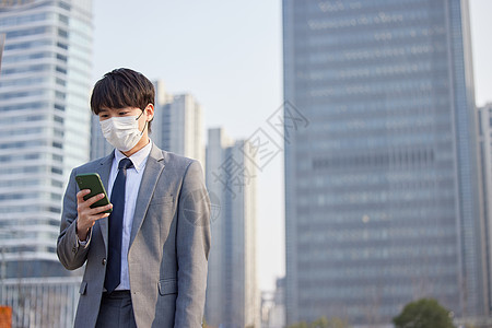 工作防疫戴口罩的商务男性室外拿着手机背景