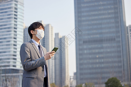 拿着手机的人戴口罩的商务男性室外拿着手机背景