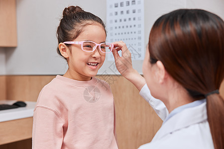 测视力的医生女医生给小女孩配眼镜背景