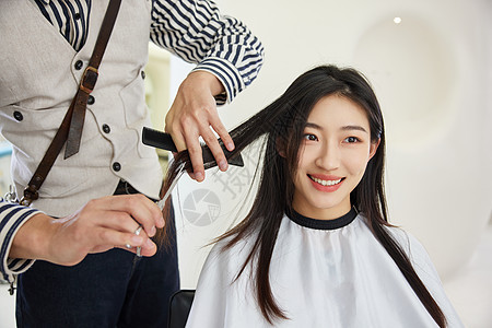 理发师给美女顾客修剪头发图片