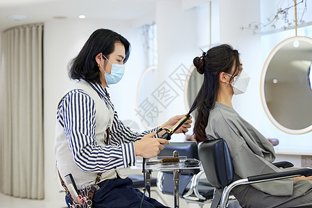 疫情期间理发师戴着口罩位顾客设计造型图片