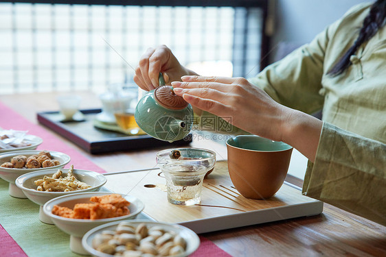 倒茶的青年女性手部特写图片