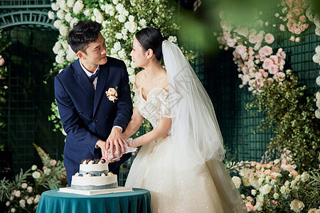 婚礼上的新郎新娘切蛋糕甜蜜相视图片