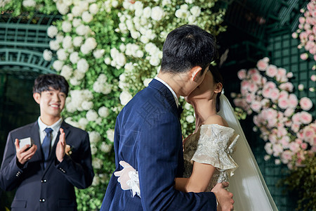 婚礼上甜蜜接吻的新郎新娘背景图片