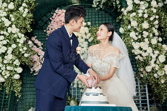 婚礼上的甜蜜新郎新娘切蛋糕图片