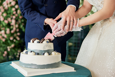 婚礼上的新郎新娘切蛋糕特写背景图片