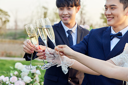 举行户外婚礼的新人举香槟庆祝图片