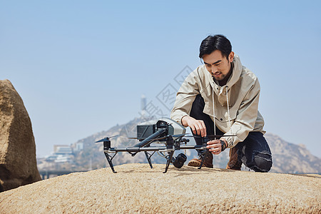 航拍摄影师携带无人机登山背景图片
