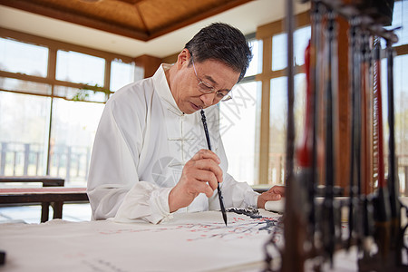 穿着传统服饰画国画的老年人背景图片