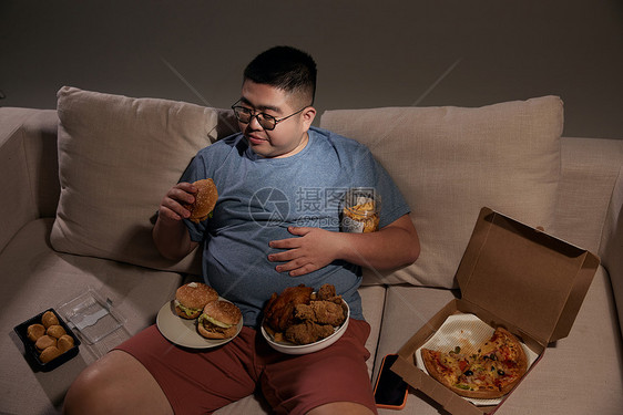 肥胖居家男士夜晚吃汉堡图片