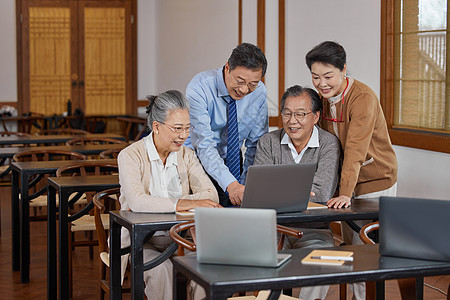 老年情侣老年大学讨论使用笔记本电脑背景