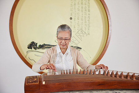 中国元素弹奏古筝的老年女性背景