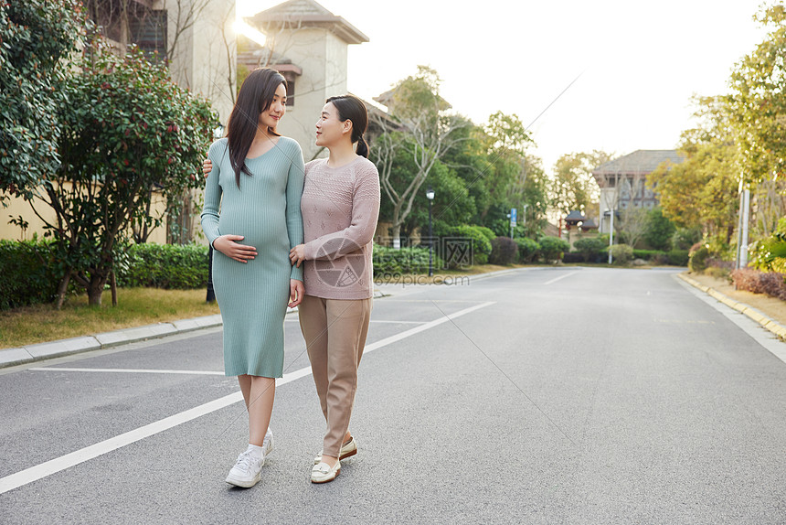 妈妈陪怀孕的女儿外出散步图片