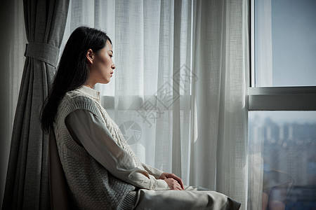 抑郁的青年女性独自在家看向窗外图片