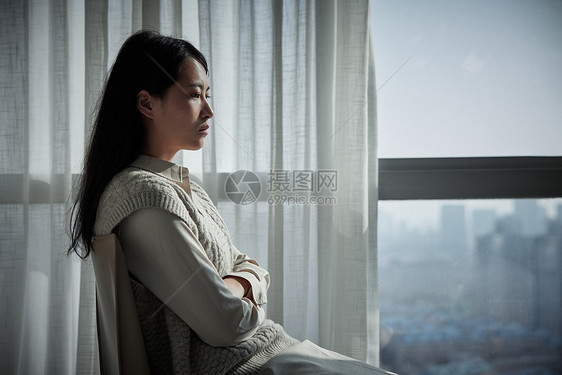 坐在窗边的抑郁女性形象图片