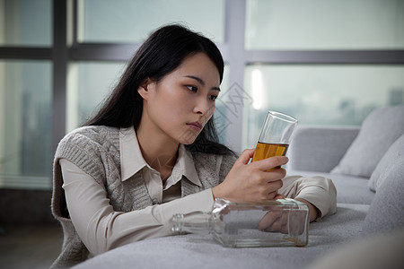 悲伤难过独自喝酒的青年女性图片