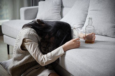 悲伤难过独自喝酒的青年女性背景