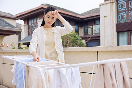 中年在室外晾晒衣服的女性形象背景