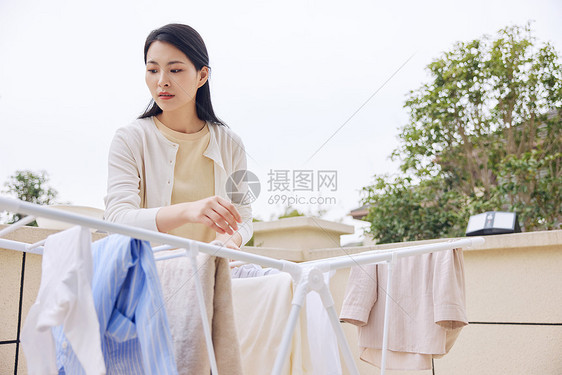 在室外晾衣服的女性形象图片